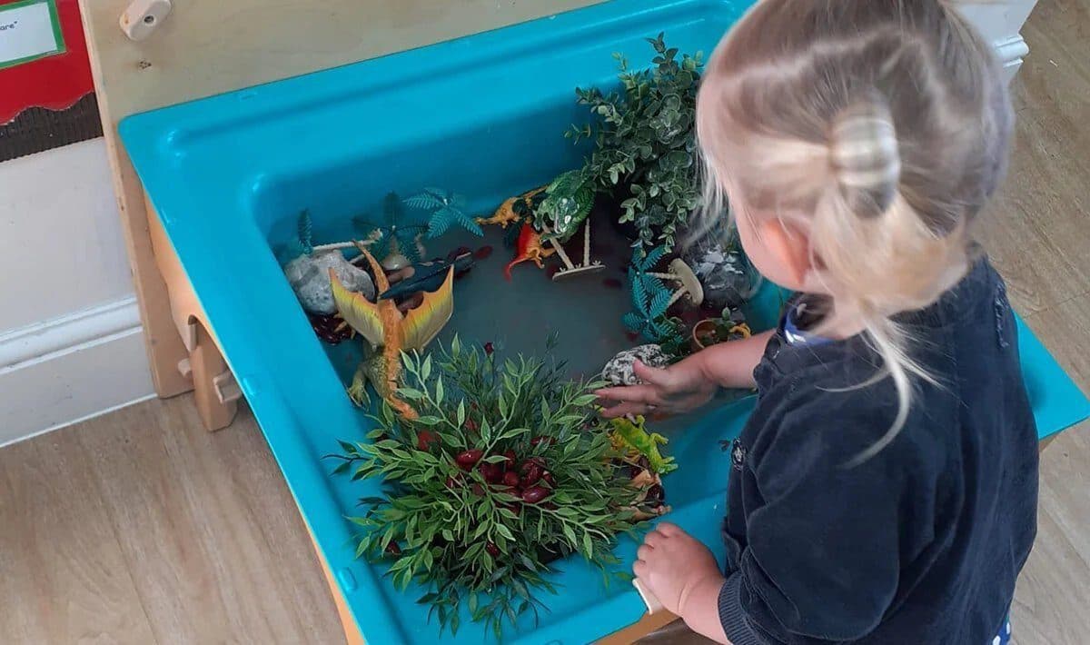 Child exploring underwater-themed sensory play bin at Blooming Years Nursery